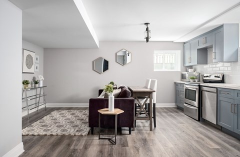 a living room with a couch and a table in a kitchen with a sink